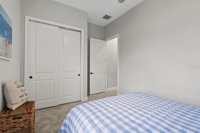 bedroom featuring visible vents, a closet, and light carpet