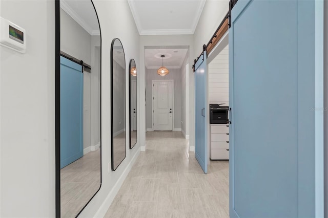 hallway with baseboards, a barn door, and ornamental molding