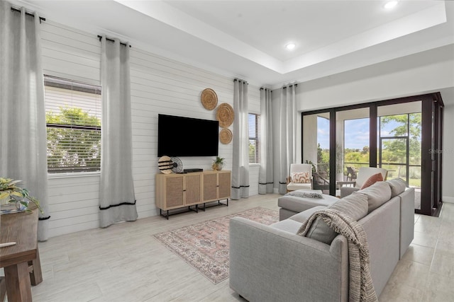 living area with plenty of natural light, a tray ceiling, and recessed lighting