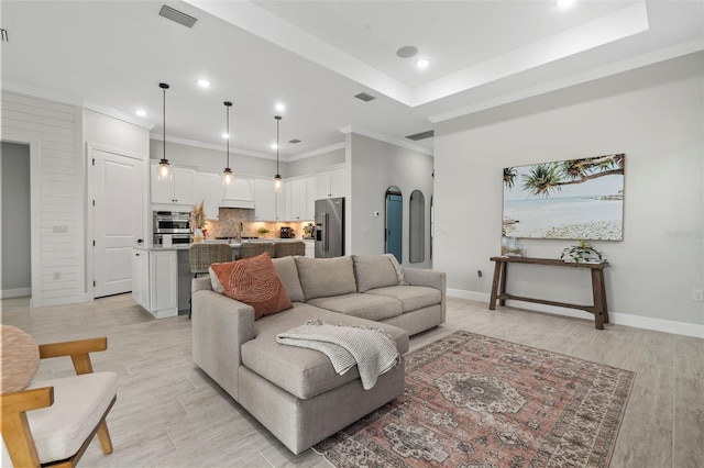 living room featuring visible vents, crown molding, arched walkways, baseboards, and recessed lighting
