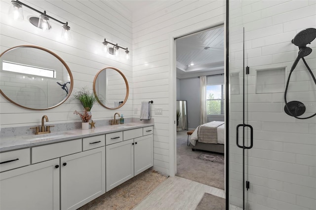 bathroom featuring double vanity, a sink, connected bathroom, and wood finished floors