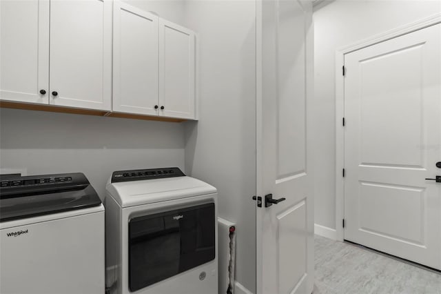 laundry area with baseboards, cabinet space, and washer and clothes dryer