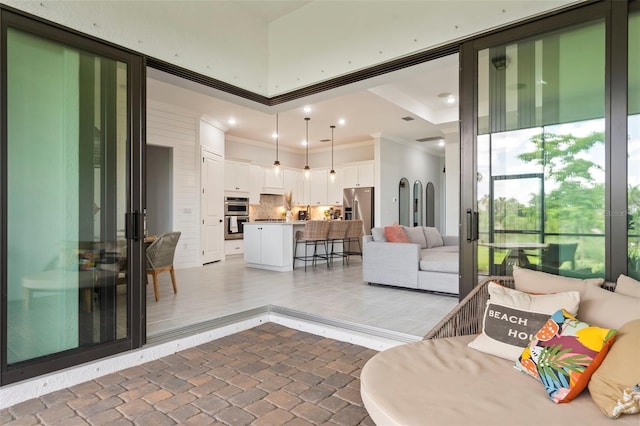 living area featuring crown molding and brick floor