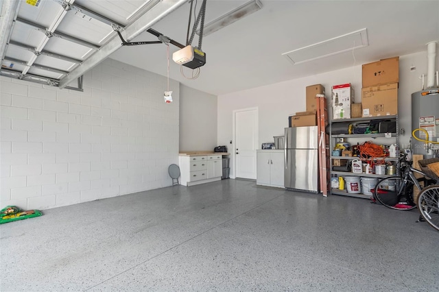 garage with freestanding refrigerator, a garage door opener, gas water heater, and concrete block wall