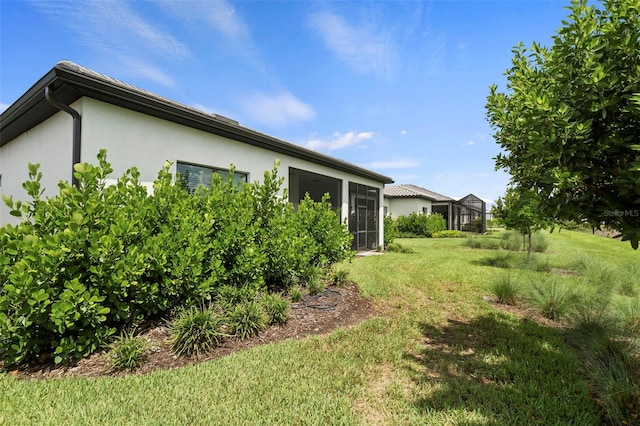 exterior space with stucco siding and a yard