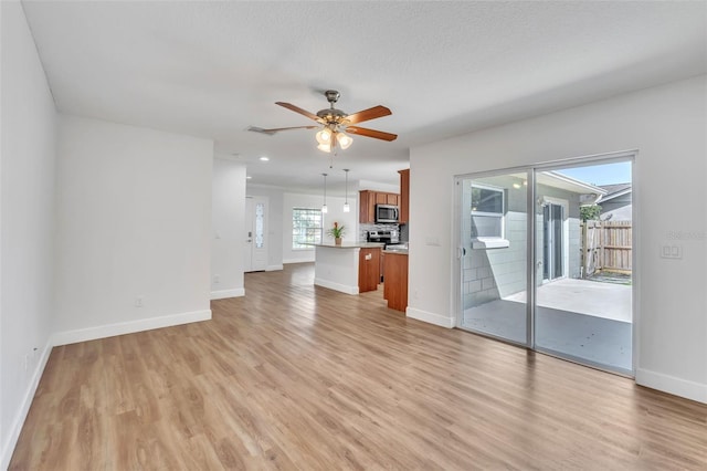 unfurnished living room featuring light wood finished floors, baseboards, ceiling fan, and recessed lighting