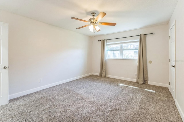 carpeted empty room featuring a ceiling fan and baseboards