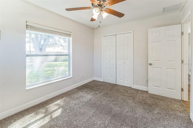 unfurnished bedroom featuring carpet floors, baseboards, a closet, and ceiling fan