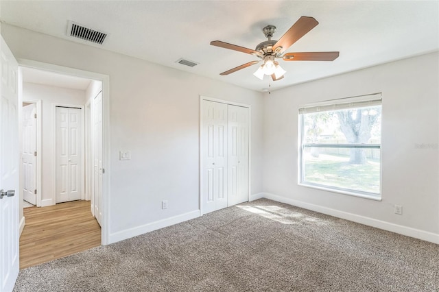 unfurnished bedroom with light carpet, baseboards, ceiling fan, and a closet