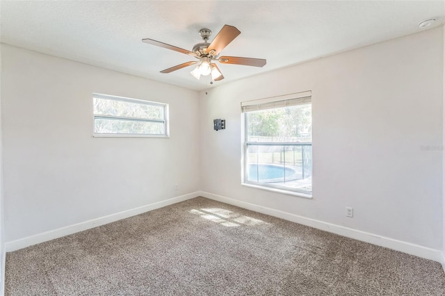 carpeted empty room with baseboards and ceiling fan