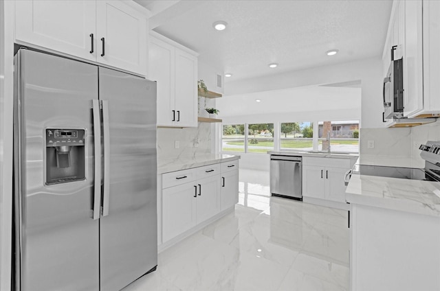 5851 SE Drew Rd, Belleview, FL 34420 - kitchen with open shelves, light stone counters, white cabinets, marble finish floor, and stainless steel appliances