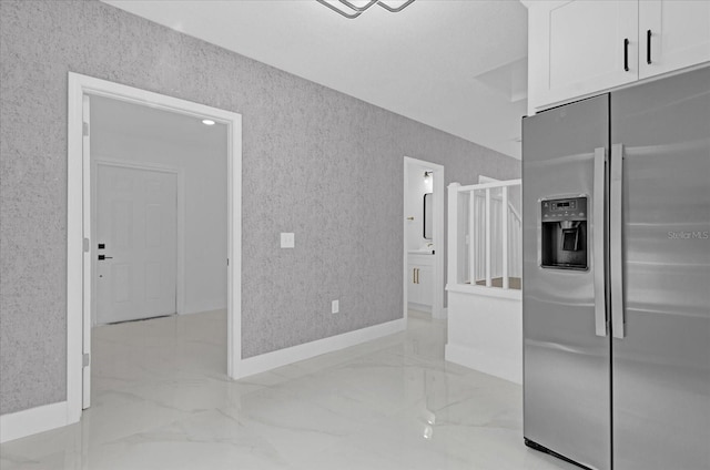 5851 SE Drew Rd, Belleview, FL 34420 - kitchen with stainless steel fridge, baseboards, white cabinetry, and marble finish floor