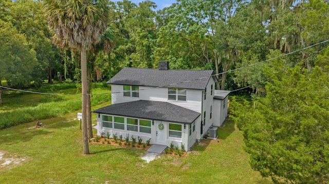 5851 SE Drew Rd, Belleview, FL 34420 - view of front facade with central air condition unit, a shingled roof, a chimney, and a front lawn
