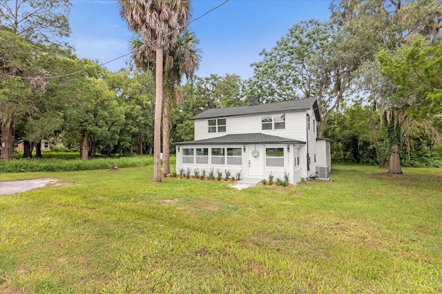 5851 SE Drew Rd, Belleview, FL 34420 - view of front of property featuring a shingled roof, a front lawn, central AC, and a chimney