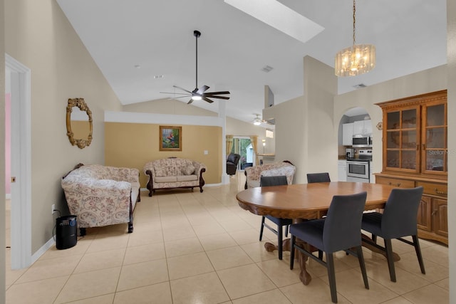 2398 Queenswood Cir, Kissimmee, FL 34743 - dining room featuring ceiling fan, a skylight, arched walkways, high vaulted ceiling, and light tile patterned floors