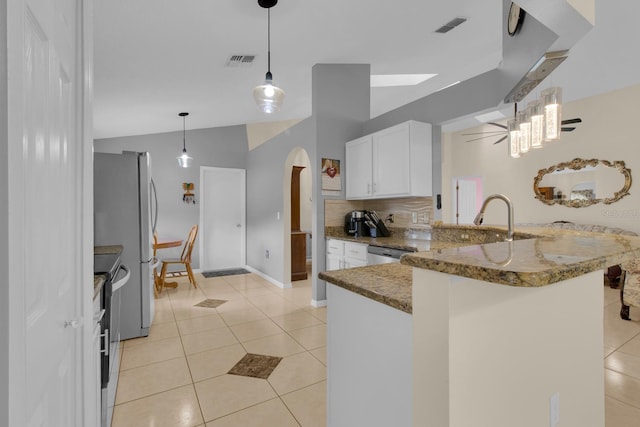2398 Queenswood Cir, Kissimmee, FL 34743 - kitchen featuring arched walkways, stone counters, light tile patterned flooring, a peninsula, and vaulted ceiling