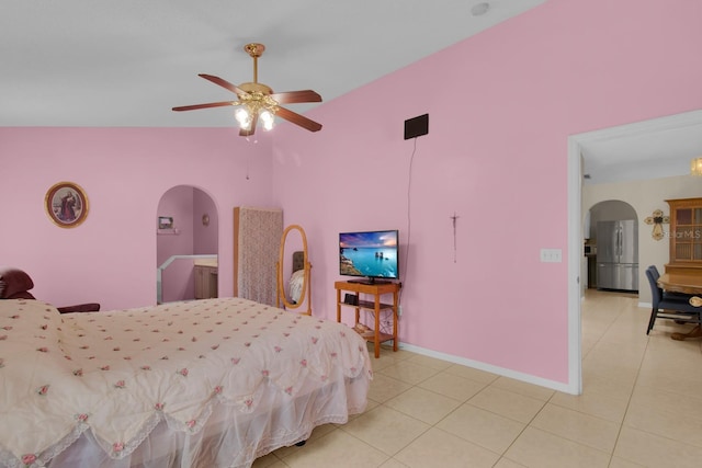2398 Queenswood Cir, Kissimmee, FL 34743 - bedroom featuring freestanding refrigerator, arched walkways, light tile patterned flooring, and ceiling fan