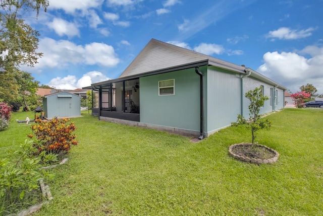 2398 Queenswood Cir, Kissimmee, FL 34743 - rear view of house with a storage unit, a sunroom, a lawn, and a ceiling fan