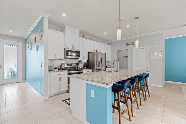 3084 Slough Creek Dr, Kissimmee, FL 34744 - kitchen featuring stainless steel appliances, a sink, tasteful backsplash, light tile patterned floors, and ornamental molding