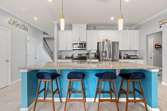3084 Slough Creek Dr, Kissimmee, FL 34744 - kitchen featuring appliances with stainless steel finishes, a sink, ornamental molding, tasteful backsplash, and a spacious island