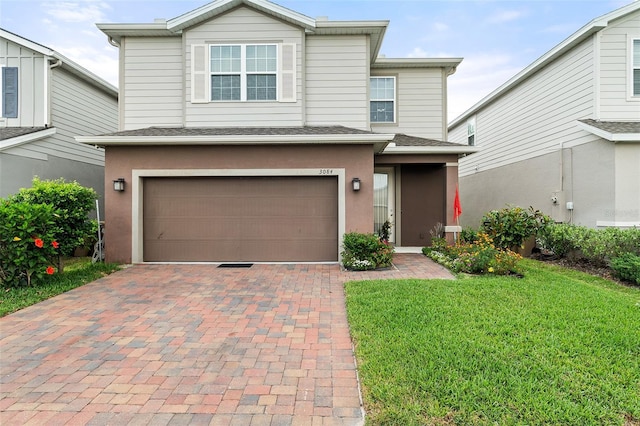 3084 Slough Creek Dr, Kissimmee, FL 34744 - traditional home with a garage, a front yard, decorative driveway, stucco siding, and roof with shingles
