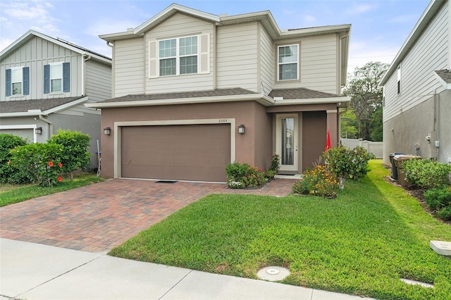 3084 Slough Creek Dr, Kissimmee, FL 34744 - view of front of house with a garage, a front yard, decorative driveway, stucco siding, and roof with shingles