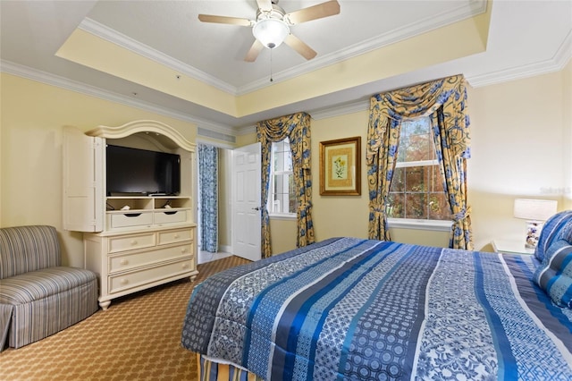carpeted bedroom featuring a raised ceiling, crown molding, and a ceiling fan