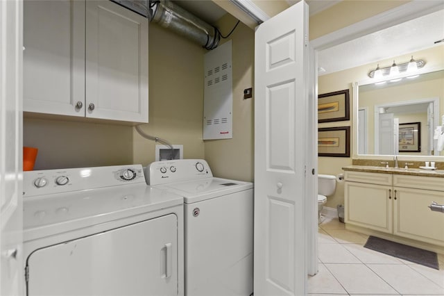 washroom with cabinet space, washer and dryer, and light tile patterned floors