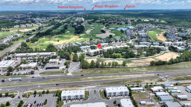 aerial view of property and surrounding area with a nearby body of water and a local golf course