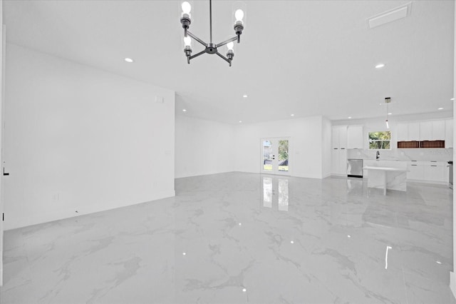 unfurnished living room featuring light marble finish floors, a chandelier, and recessed lighting