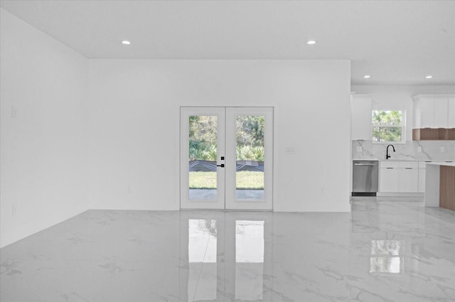 unfurnished living room with french doors, recessed lighting, and light marble finish floors