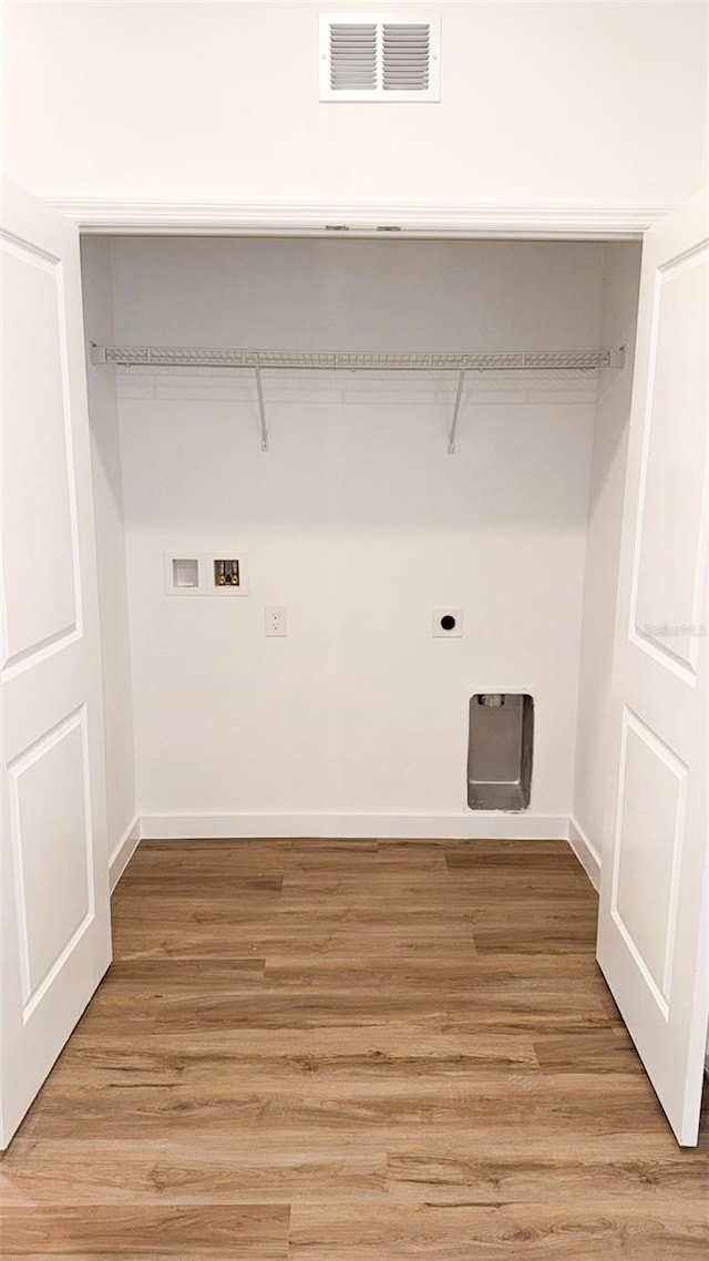 318 Cocoa Ct, Kissimmee, FL 34758 - clothes washing area featuring washer hookup, electric dryer hookup, light wood-style flooring, and baseboards