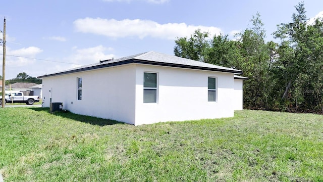 318 Cocoa Ct, Kissimmee, FL 34758 - view of property exterior featuring stucco siding, a lawn, and central AC unit