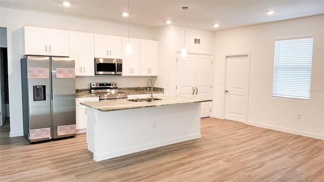 318 Cocoa Ct, Kissimmee, FL 34758 - kitchen with appliances with stainless steel finishes, a sink, light wood finished floors, a center island with sink, and white cabinets