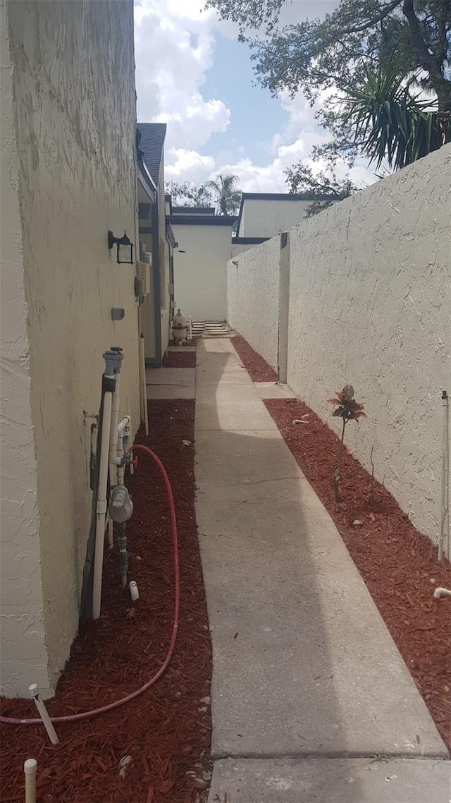 view of side of home featuring fence and stucco siding