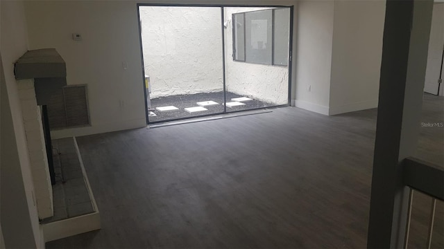 unfurnished living room with baseboards, wood finished floors, and visible vents