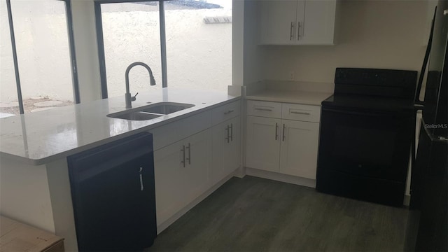 kitchen featuring electric range, wood finished floors, a sink, white cabinets, and a peninsula
