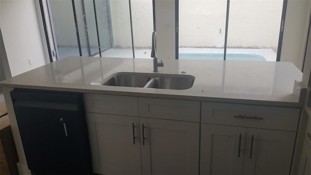 kitchen featuring a sink, light countertops, and gray cabinets