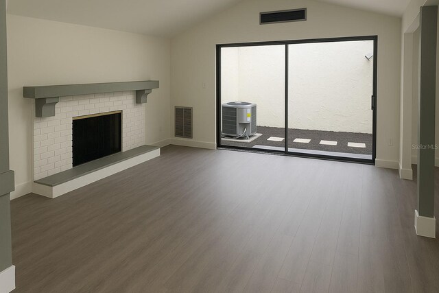 7314 Patio Row, Hudson, FL 34667 - unfurnished living room with wood finished floors, lofted ceiling, and a brick fireplace