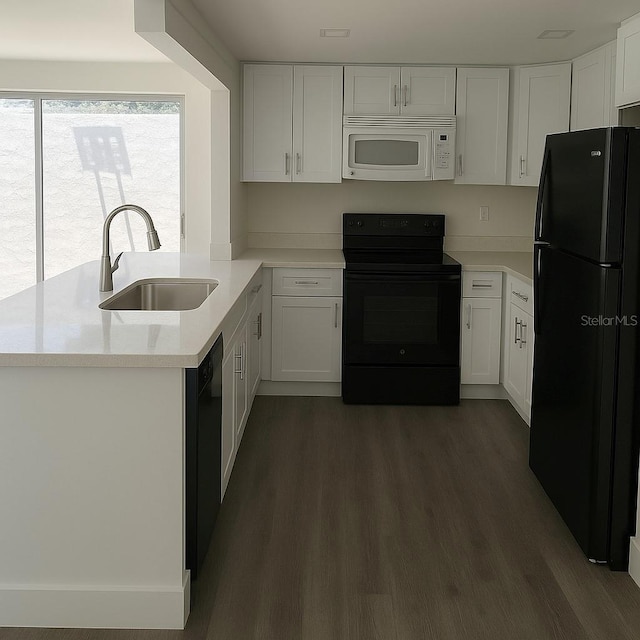 7314 Patio Row, Hudson, FL 34667 - kitchen with black appliances, dark wood finished floors, light countertops, and white cabinetry