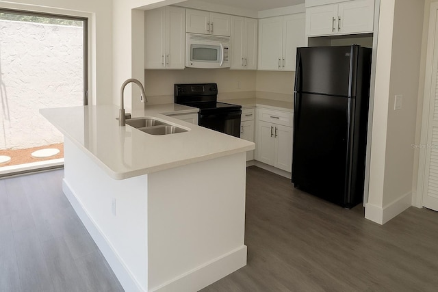 7314 Patio Row, Hudson, FL 34667 - kitchen featuring black appliances, a peninsula, dark wood-style flooring, light countertops, and white cabinets