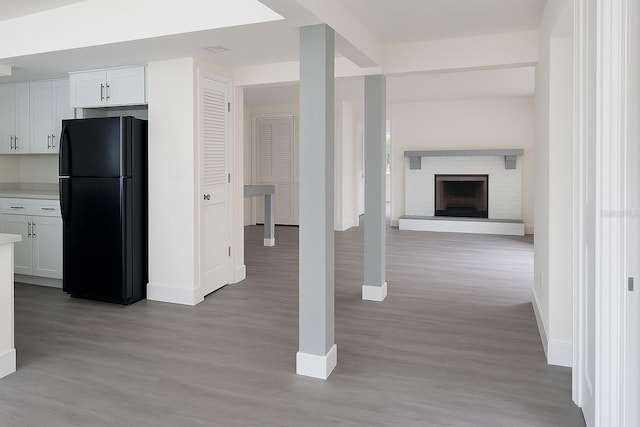 7314 Patio Row, Hudson, FL 34667 - kitchen with freestanding refrigerator, light wood-style floors, light countertops, white cabinetry, and open floor plan