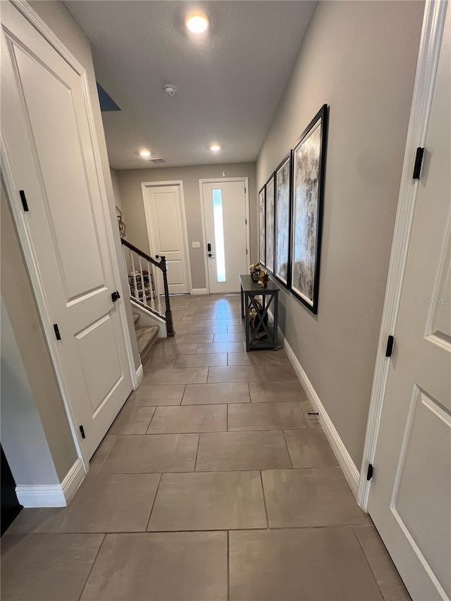 hall featuring baseboards, recessed lighting, stairs, and light tile patterned flooring