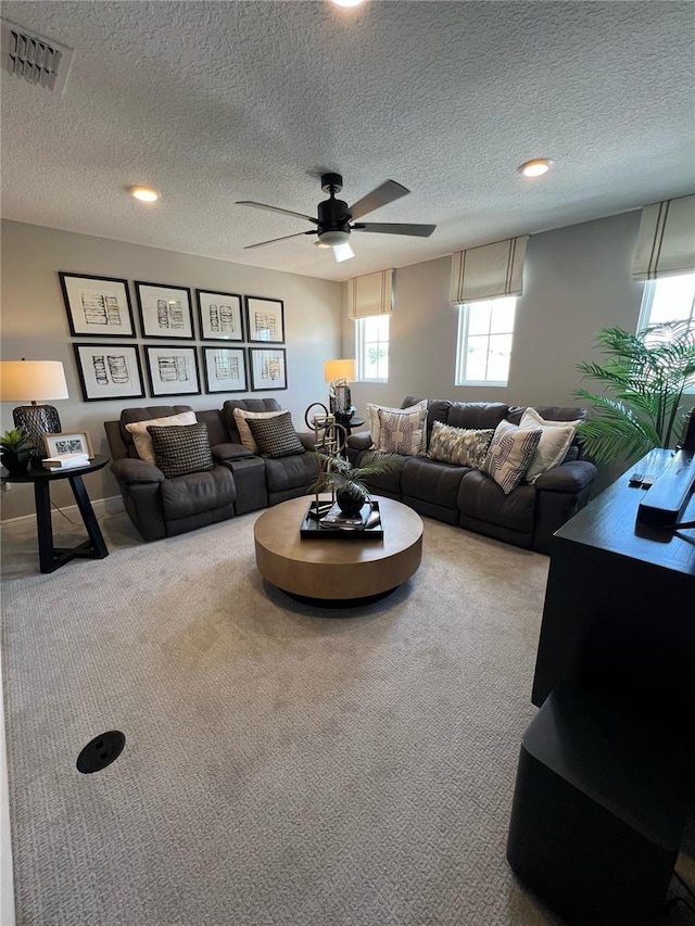 carpeted living area with a ceiling fan, recessed lighting, a textured ceiling, and visible vents