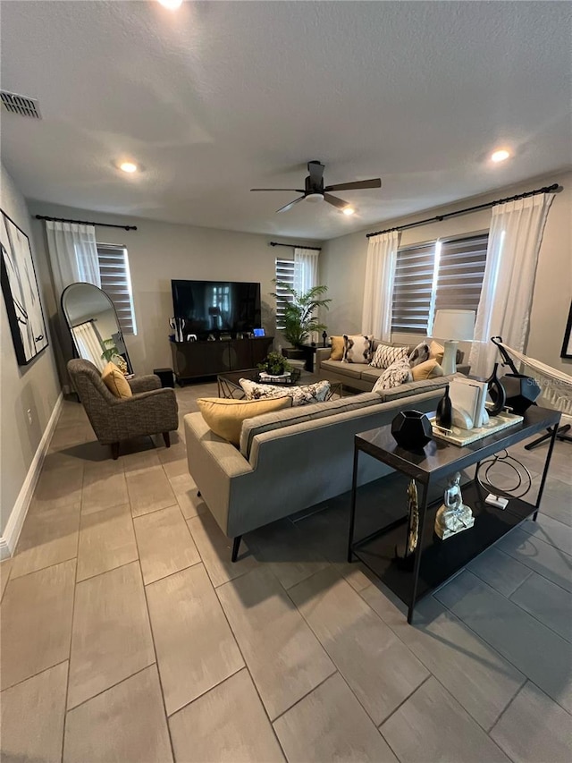 living area with a ceiling fan, visible vents, and recessed lighting