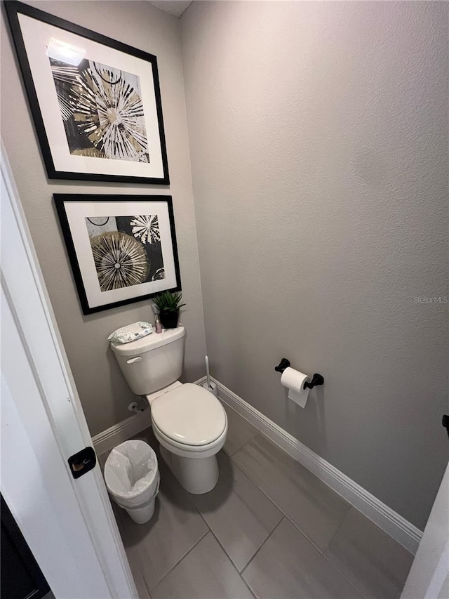 bathroom with baseboards and toilet