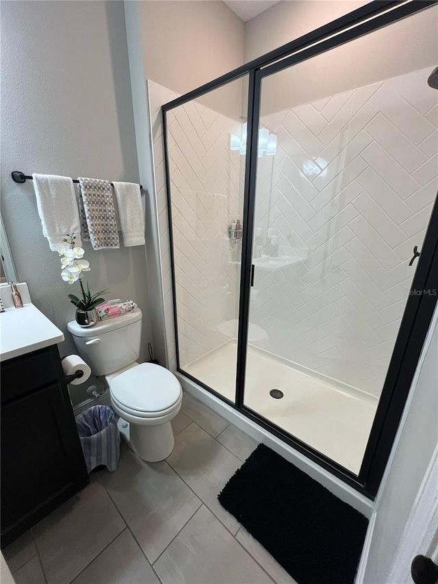 bathroom featuring vanity, tile patterned floors, a stall shower, and toilet