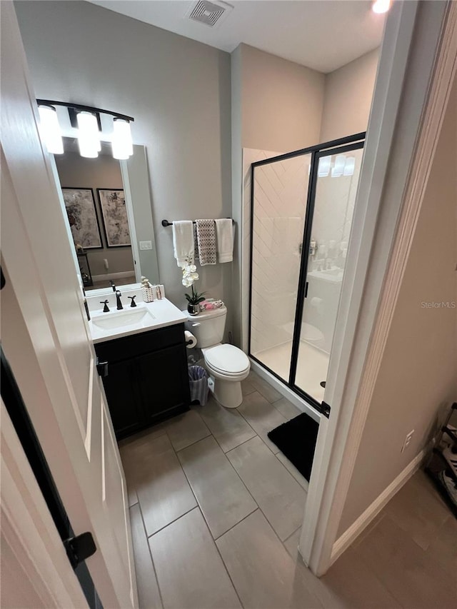 bathroom with visible vents, vanity, toilet, and a shower stall