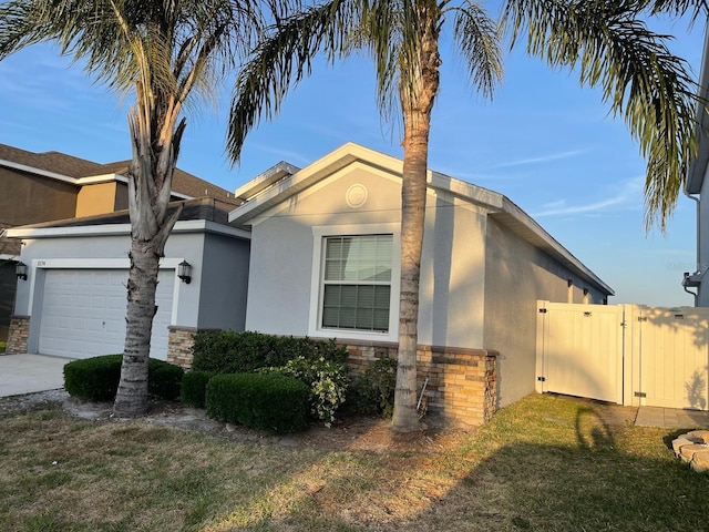1574 Thetford Cir, Orlando, FL 32824 - view of front facade featuring stucco siding, an attached garage, and stone siding