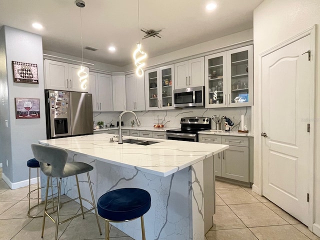 1574 Thetford Cir, Orlando, FL 32824 - kitchen with appliances with stainless steel finishes, a sink, a kitchen breakfast bar, light tile patterned floors, and light stone countertops
